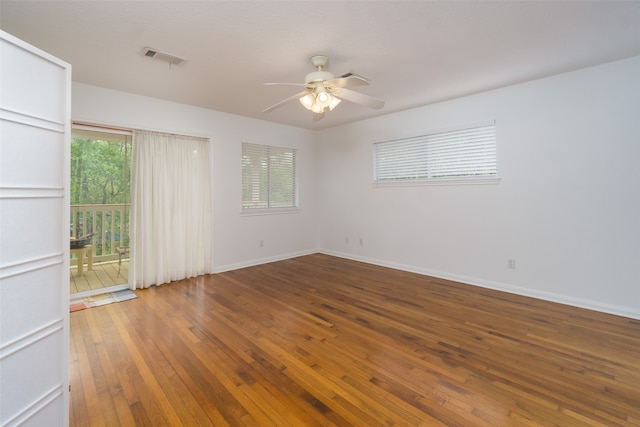 empty room with ceiling fan, a wealth of natural light, and wood-type flooring