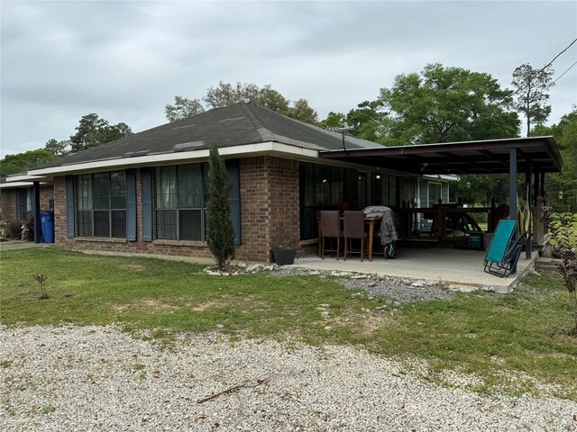 back of property with a lawn and a patio area