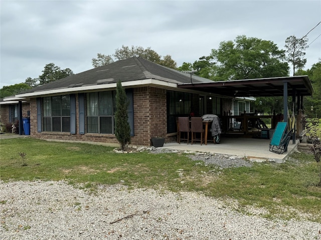 back of house with a yard, brick siding, and a patio area