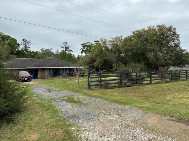 view of front of property featuring a front yard, driveway, an attached carport, and fence