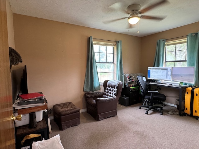 carpeted office space with a textured ceiling and ceiling fan