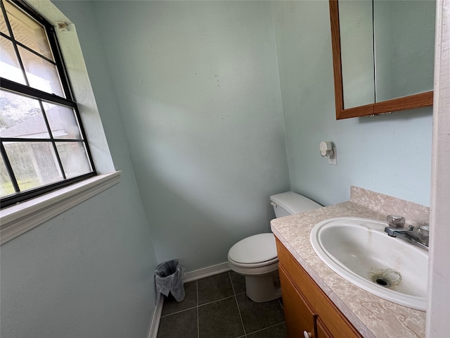 bathroom with toilet, vanity with extensive cabinet space, and tile flooring