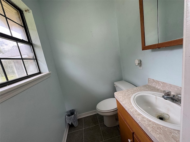 bathroom with toilet, vanity, baseboards, and tile patterned floors