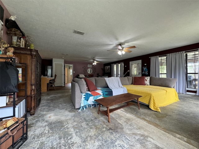 living room with a textured ceiling and ceiling fan