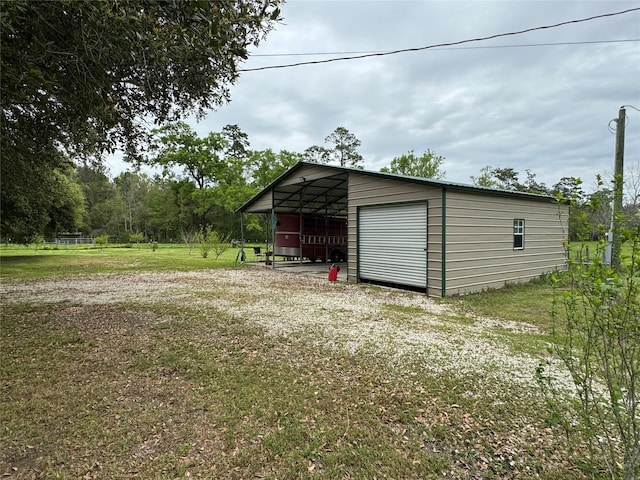 view of shed / structure with a carport, a garage, and a yard