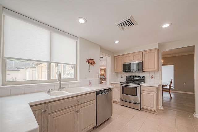 kitchen with light brown cabinets, backsplash, light tile patterned flooring, sink, and stainless steel appliances