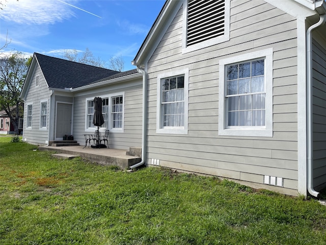 rear view of house featuring a lawn and a patio