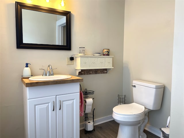 bathroom with toilet, wood-type flooring, and vanity