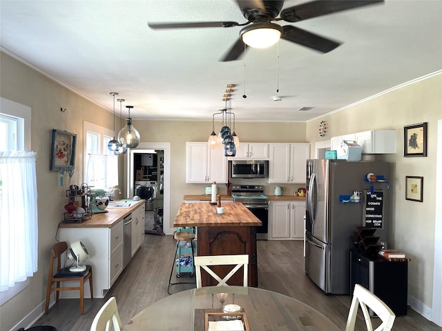 kitchen with appliances with stainless steel finishes, a center island, ceiling fan, dark hardwood / wood-style flooring, and white cabinetry