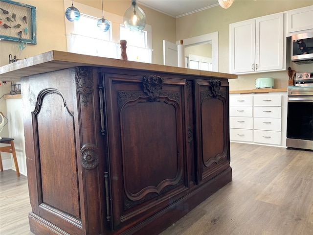 interior details featuring crown molding, appliances with stainless steel finishes, and light wood-type flooring