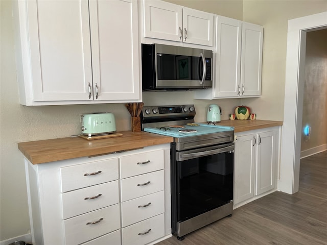 kitchen featuring white cabinets, butcher block countertops, stainless steel appliances, and dark wood-type flooring