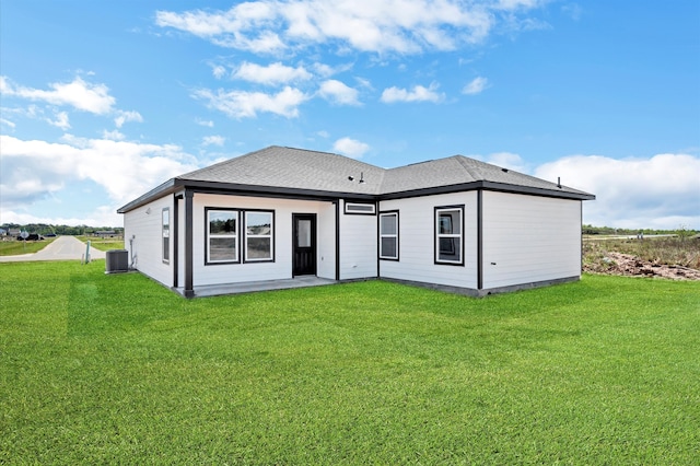 rear view of house featuring a lawn and central AC unit