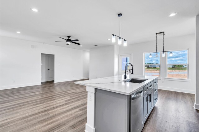 kitchen featuring hanging light fixtures, dark hardwood / wood-style flooring, an island with sink, stainless steel dishwasher, and sink