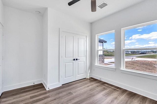 unfurnished bedroom with a closet, ceiling fan, and hardwood / wood-style floors