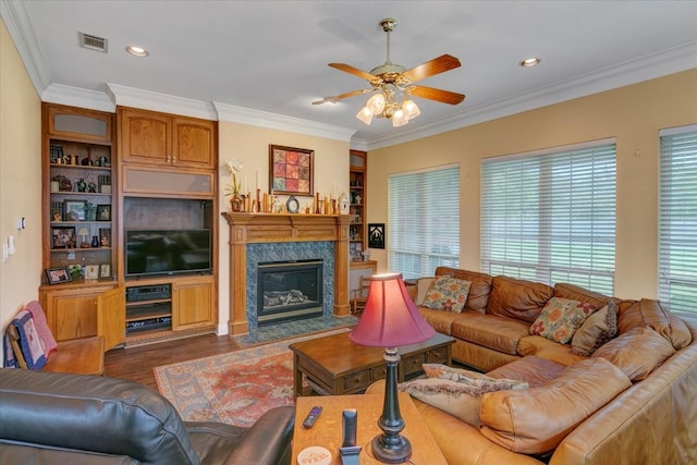 living room featuring ceiling fan, dark wood-type flooring, a high end fireplace, and plenty of natural light