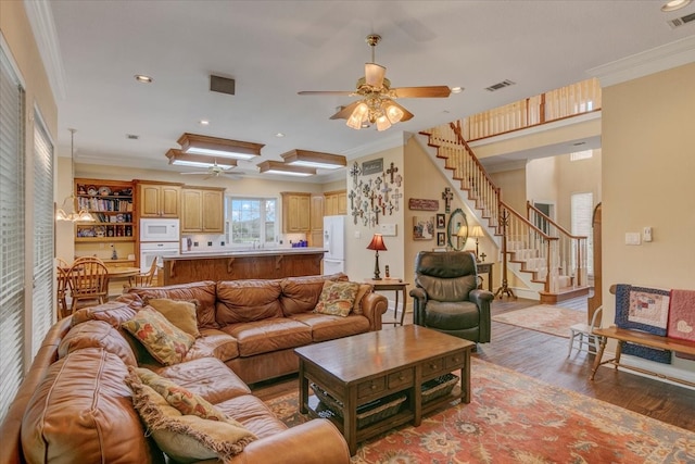 living room featuring ceiling fan, light wood-type flooring, and crown molding