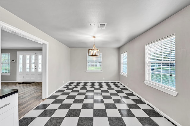 interior space featuring dark hardwood / wood-style flooring, a chandelier, and a healthy amount of sunlight