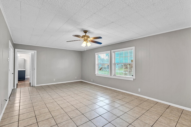 tiled empty room featuring ceiling fan