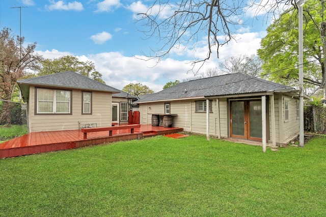 back of property with a wooden deck and a lawn