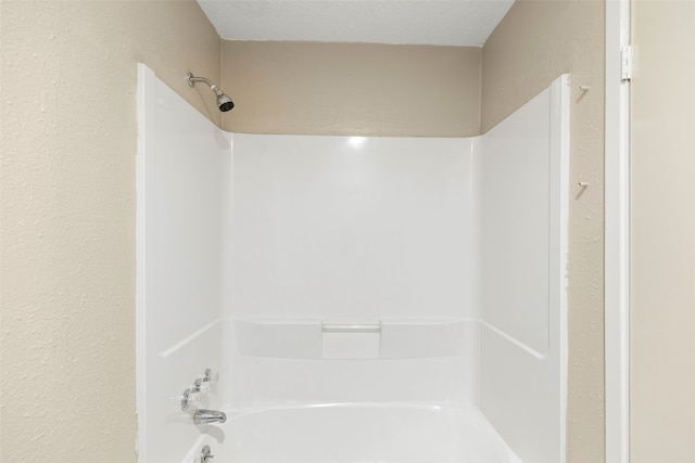 bathroom with shower / washtub combination and a textured ceiling