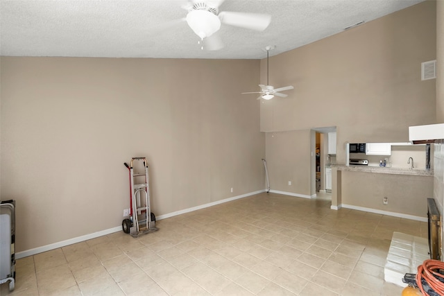 interior space featuring ceiling fan, high vaulted ceiling, a textured ceiling, and sink