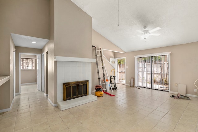 unfurnished living room with a fireplace, a textured ceiling, light tile floors, and ceiling fan