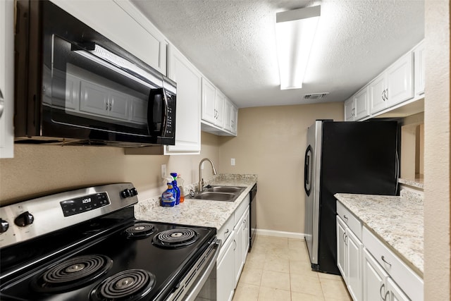 kitchen featuring appliances with stainless steel finishes, white cabinetry, light tile floors, a textured ceiling, and sink