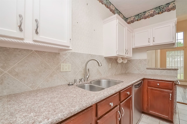 kitchen with white cabinetry, sink, light tile floors, dishwasher, and tasteful backsplash