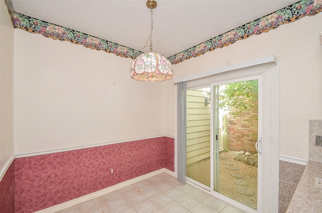 spare room with a textured ceiling and light tile floors