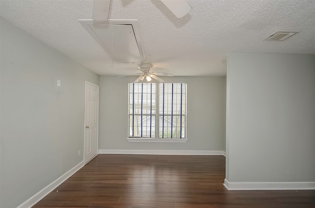 empty room featuring dark hardwood / wood-style flooring, ceiling fan, and a textured ceiling