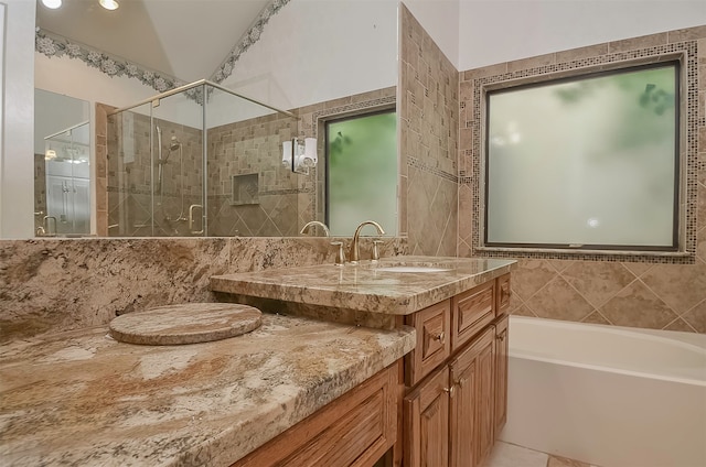 bathroom featuring shower with separate bathtub, tile floors, tile walls, and vanity