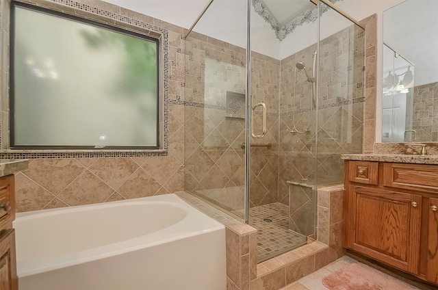 bathroom featuring vanity, plus walk in shower, tile floors, and tile walls