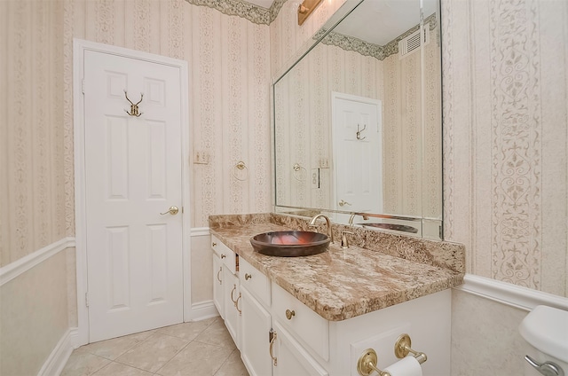 bathroom with toilet, large vanity, and tile floors