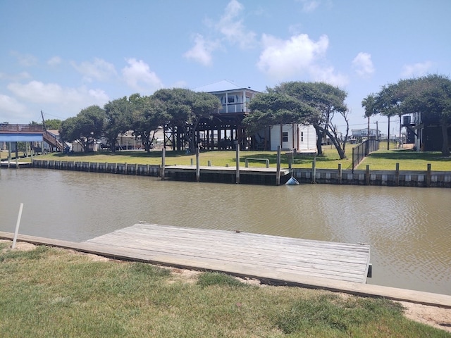 view of dock featuring a water view and a yard