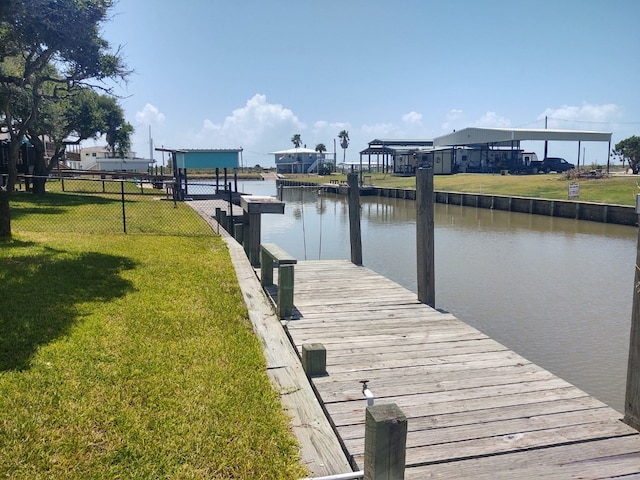 dock area featuring a lawn and a water view