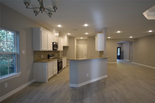 kitchen featuring white cabinetry, appliances with stainless steel finishes, light stone counters, and light hardwood / wood-style floors