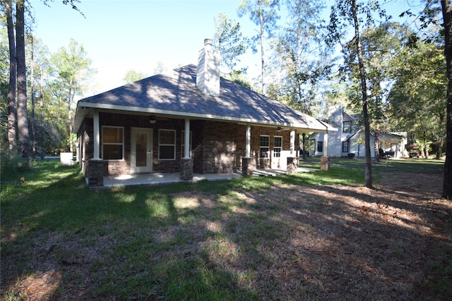 rear view of property with a yard