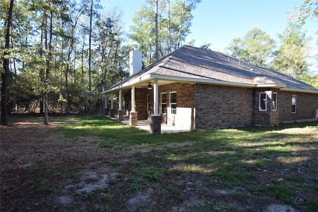 back of property featuring a lawn and a patio area