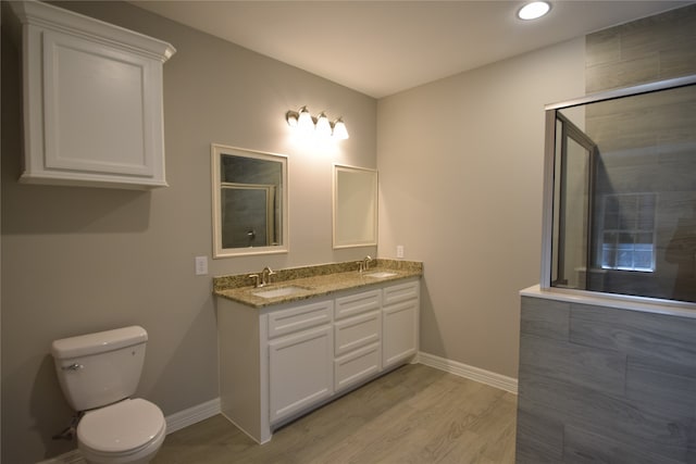 bathroom with dual sinks, toilet, hardwood / wood-style flooring, and oversized vanity