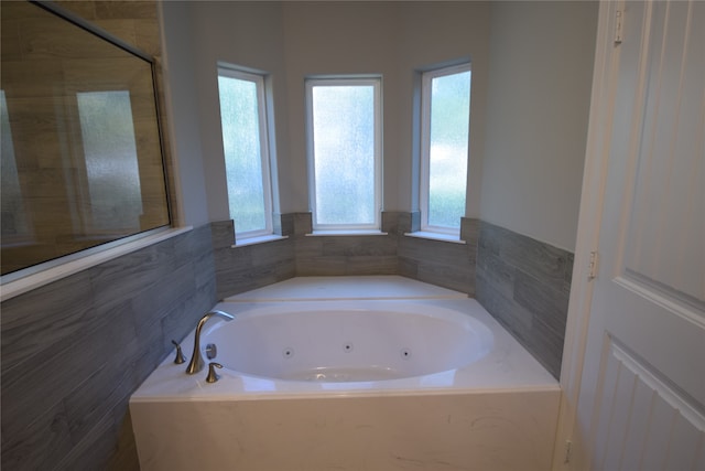 bathroom featuring a relaxing tiled bath