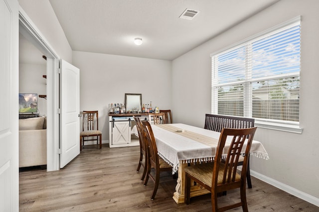 dining space with wood-type flooring