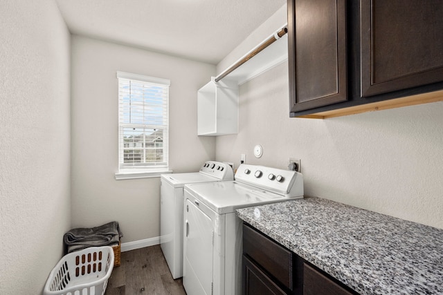 laundry area featuring cabinets, washer and dryer, hookup for an electric dryer, and light hardwood / wood-style flooring