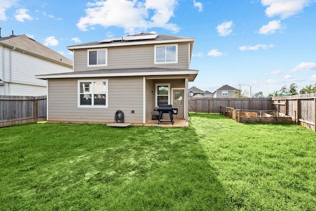 rear view of house featuring solar panels, a yard, and a patio area