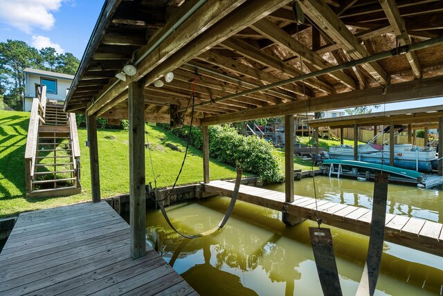 dock area with a water view and a yard