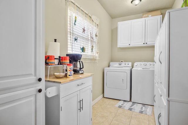 laundry room featuring independent washer and dryer, cabinets, and light tile flooring