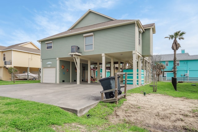 back of house with a yard and a garage