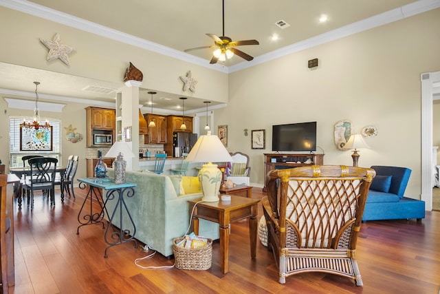 living room featuring ornamental molding, dark hardwood / wood-style floors, and ceiling fan with notable chandelier