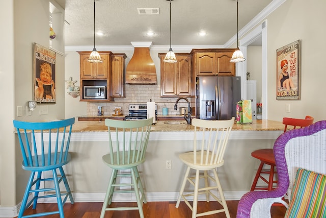 kitchen with custom range hood, appliances with stainless steel finishes, a breakfast bar, sink, and dark hardwood / wood-style floors