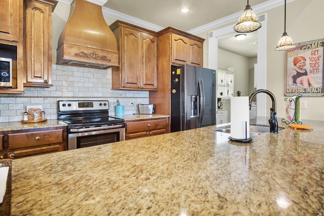 kitchen with tasteful backsplash, stainless steel appliances, premium range hood, decorative light fixtures, and light stone countertops