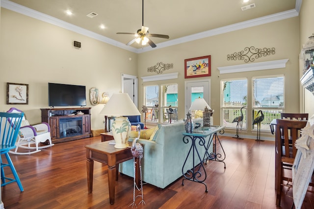 living room with ceiling fan, crown molding, a towering ceiling, and dark hardwood / wood-style floors